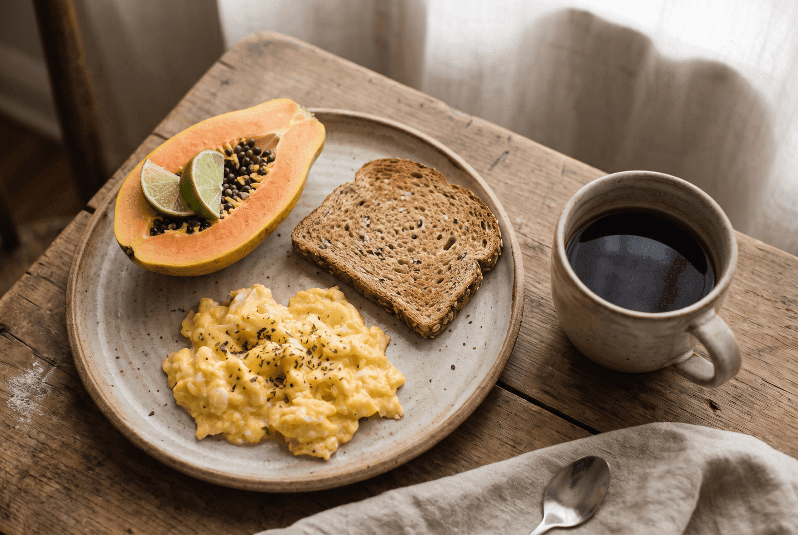 Café da manhã com ovo mexido, pão integral, mamão e café sem açúcar